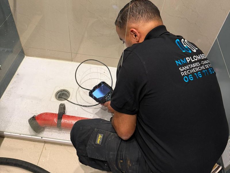 Technicien NM Plomberie réalisant une recherche de fuite par inspection caméra dans une douche
